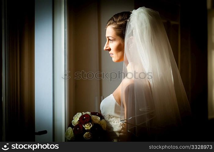 Bride at her wedding day - she is looking out of the window