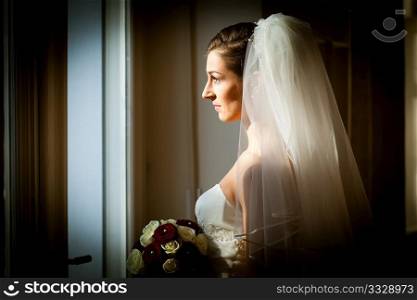 Bride at her wedding day - she is looking out of the window