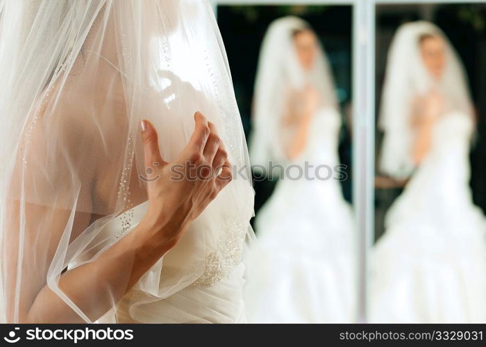 Bride at the clothes shop for wedding dresses; she is choosing a dress