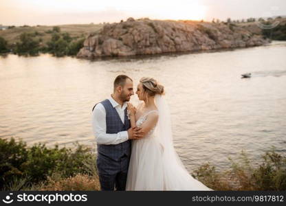 bride blonde girl and groom near the river at sunset light