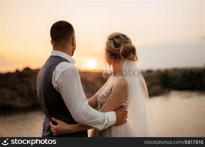 bride blonde girl and groom near the river at sunset light