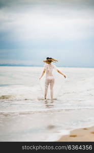 bride close-up under a veil against a background of blue sky and black sea