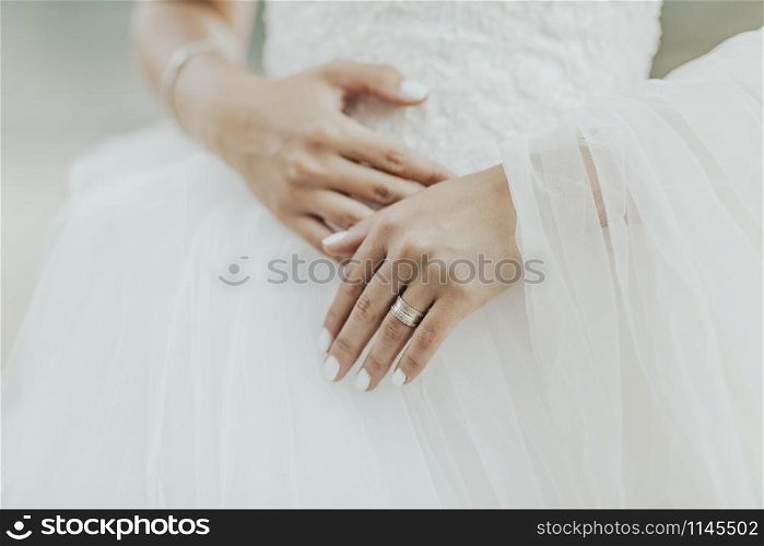 Bride dressed in wedding dress and her hands