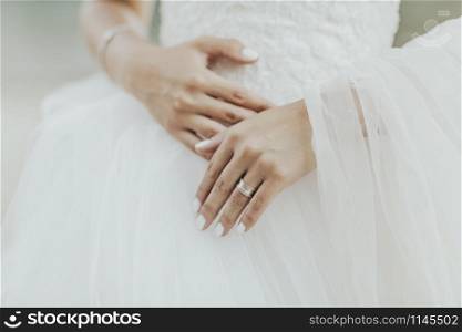 Bride dressed in wedding dress and her hands
