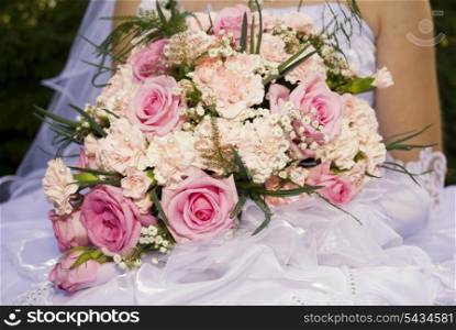 Bride hold the bouquet from pink roses and carnations