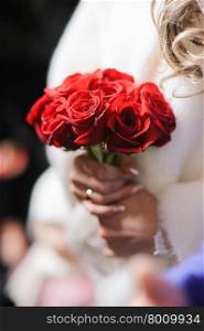 Bride holding a bouquet of beautiful red roses