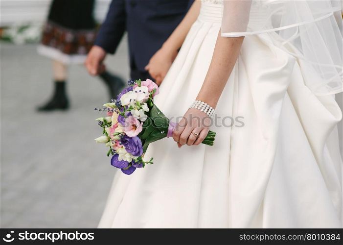 Bride holding a bouquet of beautiful roses. Wedding day
