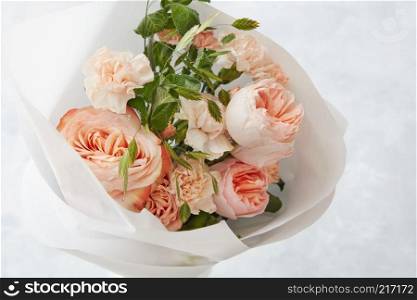 Bride holding wedding bouquet of roses on a gray stone background. Beautiful pink roses