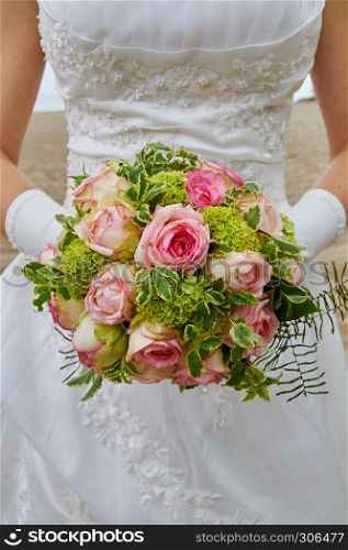 bride holding wedding bouquet pink roses