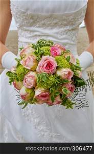bride holding wedding bouquet pink roses
