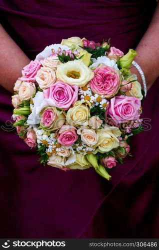 bride holding wedding bouquet with roses