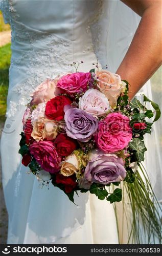 bride holding wedding bouquet with roses