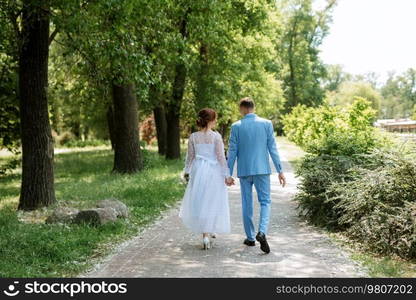 bride in a light wedding dress with a bouquet next to the groom in a blue suit