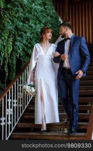 bride in a white dress with a bouquet and the groom in a blue suit on their wedding day