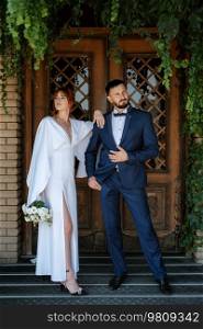 bride in a white dress with a bouquet and the groom in a blue suit on their wedding day