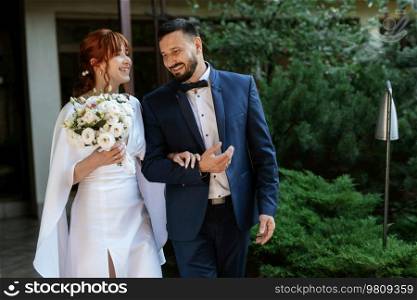 bride in a white dress with a bouquet and the groom in a blue suit on their wedding day