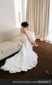 bride in a white dress with a bouquet in a hotel room