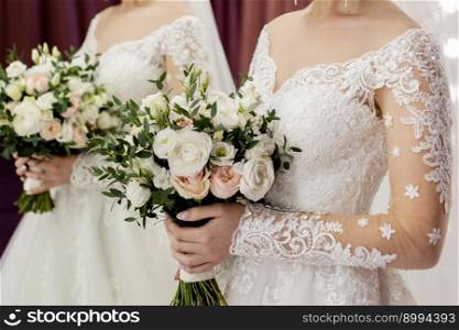 bride in a white wedding dress holds her wedding bouquet in her hands. the bride in a white wedding dress holds her wedding bouquet in her hands