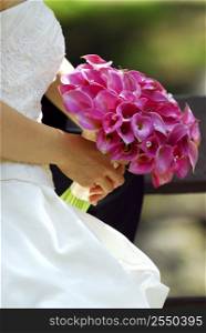 Bride in wedding gown holding bouquet of pink flowers