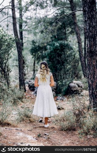 bride in white dress walking alone in the Forest
