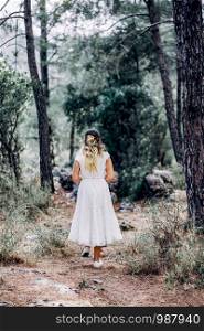 bride in white dress walking alone in the Forest