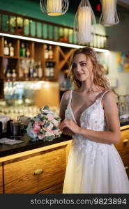 bride inside the cocktail bar at the bar in a bright atmosphere