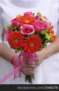 Bride is holding bouquet of different colors of flowers