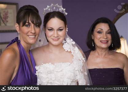 Bride, maid of honor and mother of the bride pose before wedding