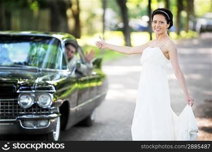 bride near car after their wedding ceremony