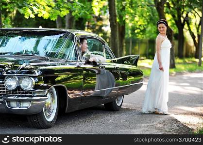 bride near car after their wedding ceremony