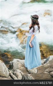 bride on the background of a mountain waterfall