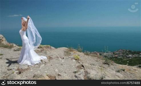 Bride Posing in the mountains against the blue sky