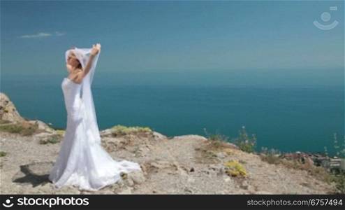 Bride Posing in the mountains against the blue sky