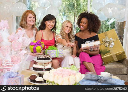 Bride sitting together with her Friends showing engagement ring at Bridal Shower