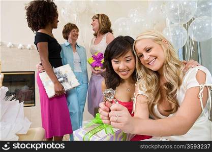 Bride sitting with her Friend looking at large engagement ring at Bridal Shower