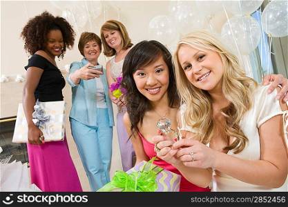 Bride sitting with her Friend showing large engagement ring at Bridal Shower