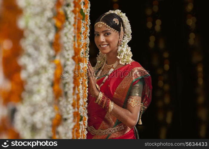 Bride standing by garlands