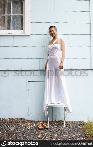 Bride standing on a stool and grinning