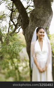 Bride standing under a tree and smiling