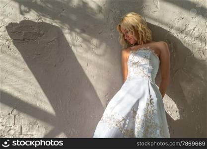 Bride stands about the plastered walls