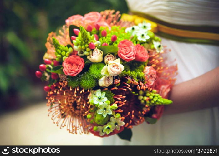 Bride with bouquet from different flowers. Close up