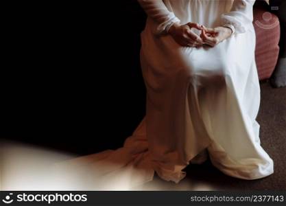 brides morning. Portraits of a bride in long white dress is sitting with folded arms. Woman is preparing for her wedding day.. brides morning. Portraits of a bride in long white dress is sitting with folded arms. Woman is preparing for her wedding day