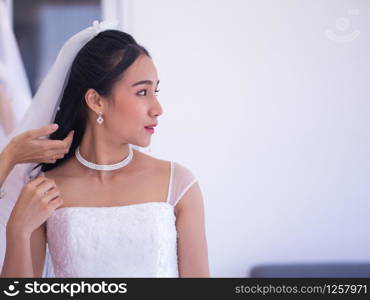 bridesmaid helping set bride hair and bridal veil into a beautiful position