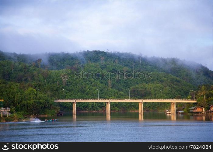 Bridge across the river. The mist covered mountains in the background.