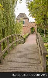 Bridge and alley leading to historic city wall with watchtower and gate at the of Hattem, the Netherlands.