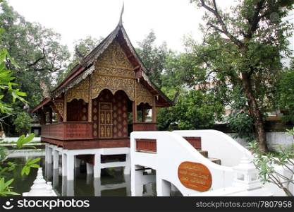 Bridge and small wooden temple on the pond in Wat Chiang Man, Chiang Mai, Thailand