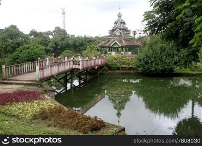 Bridge and wooden pagoda on island in public park, Yangon, Myanmar