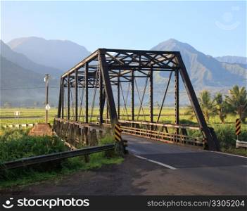 Bridge on the road between Princeville and Hanalei with mountains in the rear