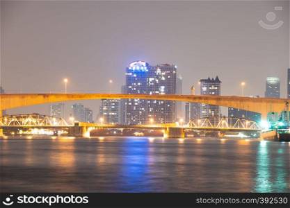 Bridge over river in Bangkok city. Twilight cityscape building and skyscraper in Bangkok city.