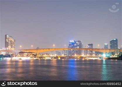 Bridge over river in Bangkok city. Twilight cityscape building and skyscraper in Bangkok city.